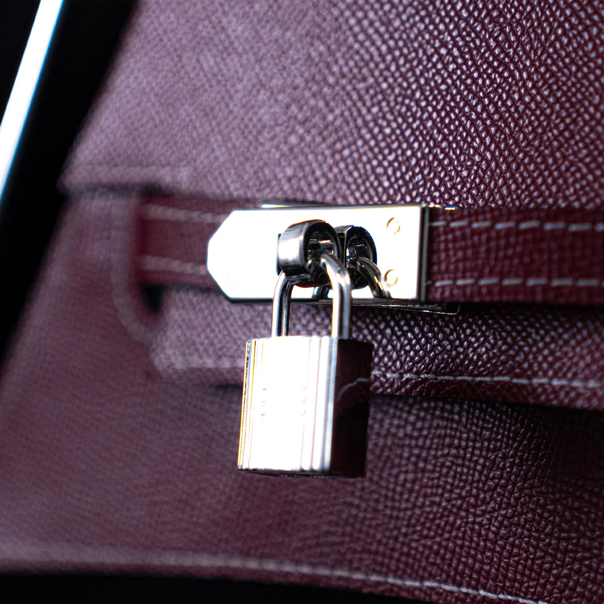Grace, padlock and strap on the bordeaux leather sail